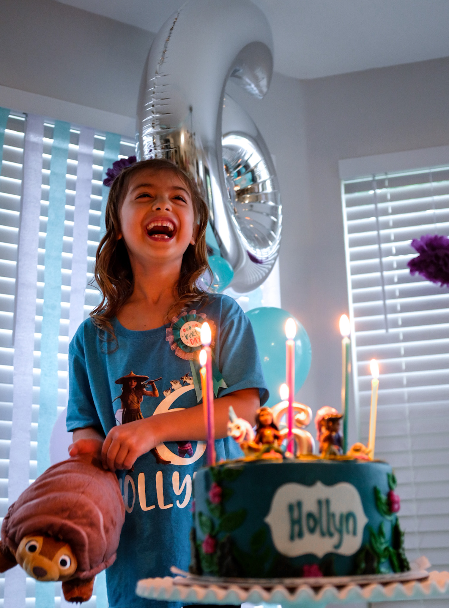 girl laughing next to birthday cake
